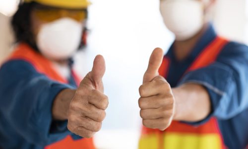 colleagues-with-safety-equipment-showing-ok-sign